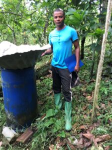 Image of a man standing next to a large blue barrel.